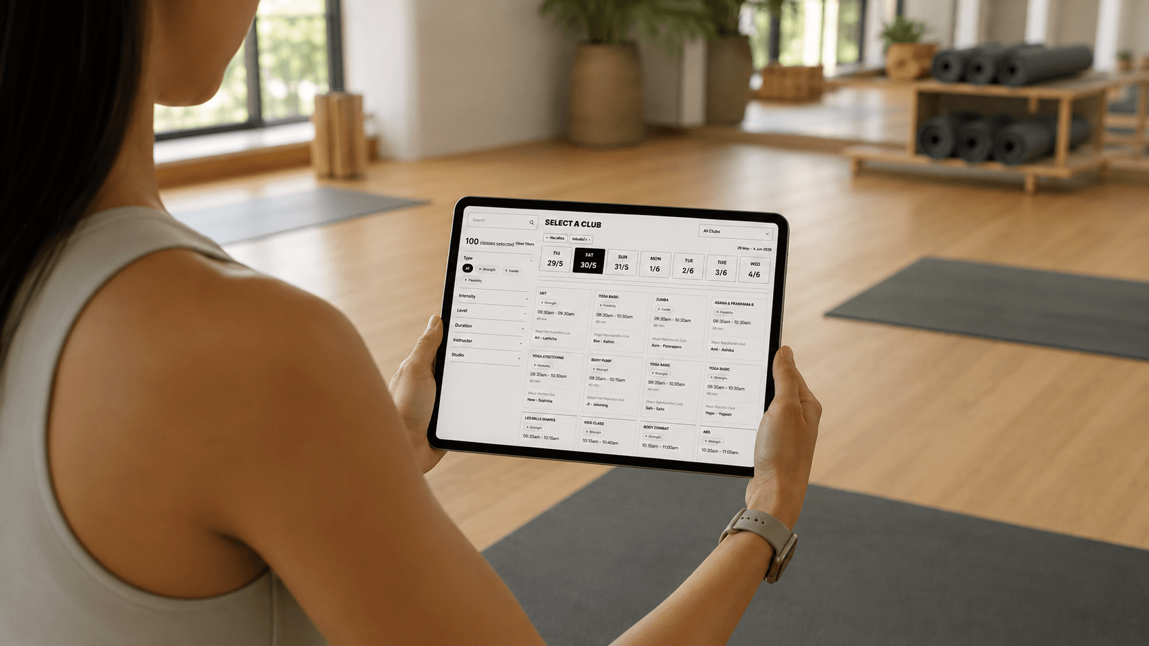 Woman browsing fitness class schedule in a modern yoga studio